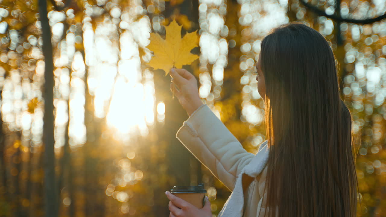 Woman enjoying autumn scenery with a coffee cup