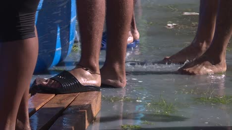 close up, migrants feet wet while they are washing clothes