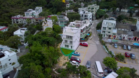 ariel drone dolly push out over village house sai kung hong kong. revealing rural village estate pull back hd 4k drone shot.