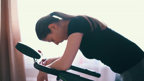 tired woman leans on modern treadmill after training in room