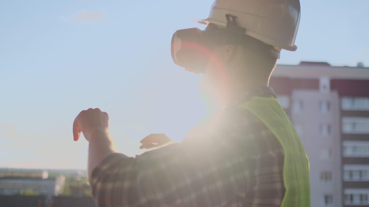 ingeniero constructor en el techo del edificio al atardecer se encuentra en gafas vr y mueve sus manos usando la interfaz del futuro. ingeniero futurista del futuro. la vista desde la parte de atrás