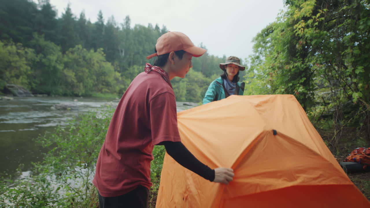 Asian Women Placing Tent at Campsite