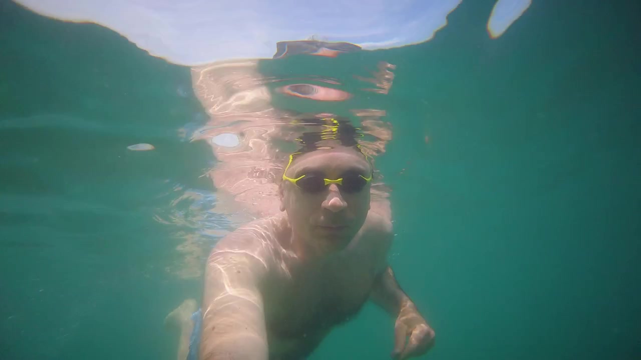 Filmato dinamico subacqueo in soggettiva di un nuotatore che si muove in acqua di mare cristallina