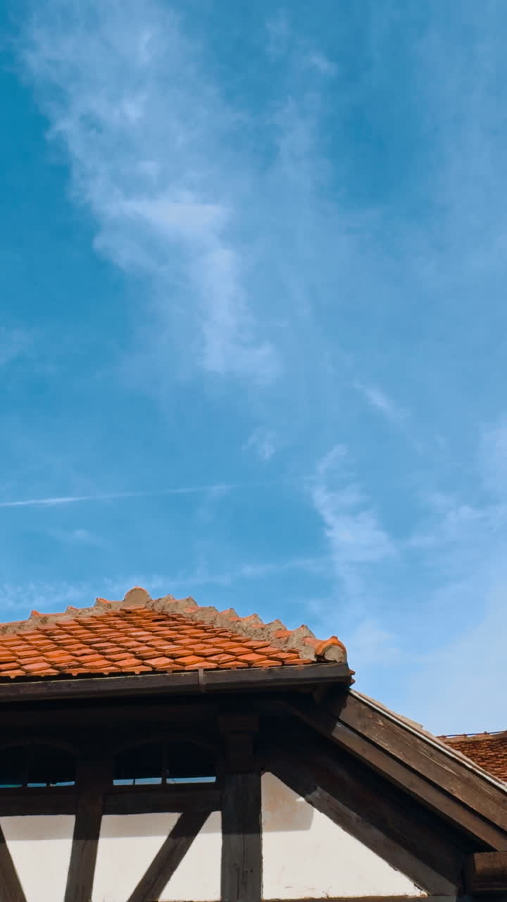 Rooftops of old castle covered with red tiles. Castle Bran of notorious Dracula in Romania. Low angle view. Vertical video