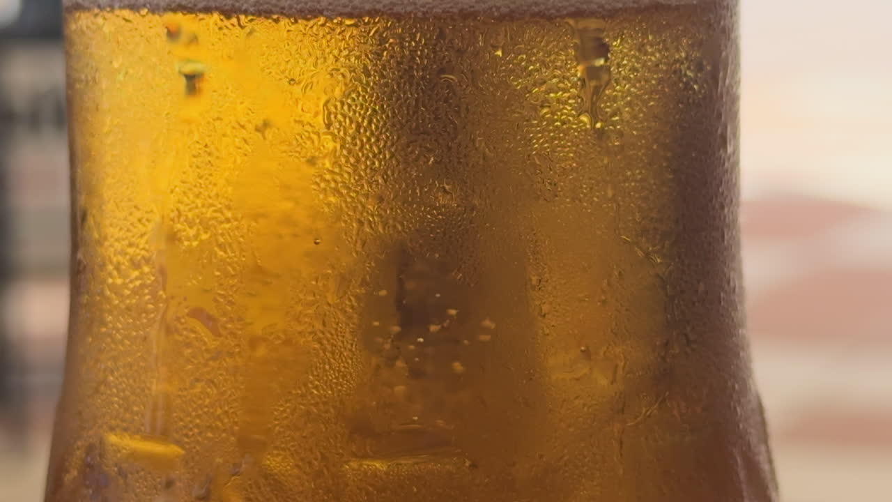 vista cercana de una cerveza fría con burbujas subiendo