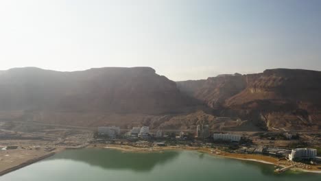 Panorámica-De-Drones-Aéreos-De-4k-En-Las-Montañas-Rocosas-Cerca-De-La-Zona-Hotelera-Del-Mar-Muerto