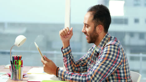 Casual-businessman-using-tablet-at-desk-