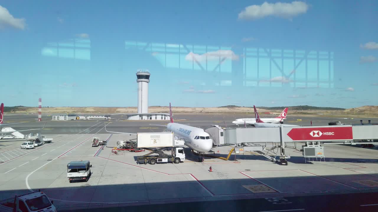 부분적으로 구름이 많은 낮에, 지상 서비스는 이스탄불 공항의 기지에서 주차 된 터키 항공기의 항공기를 로드합니다.