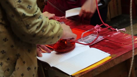 Travellers-stamping-Goshuin-with-a-Geisha-motif-in-Gion-Temple-as-souvenir