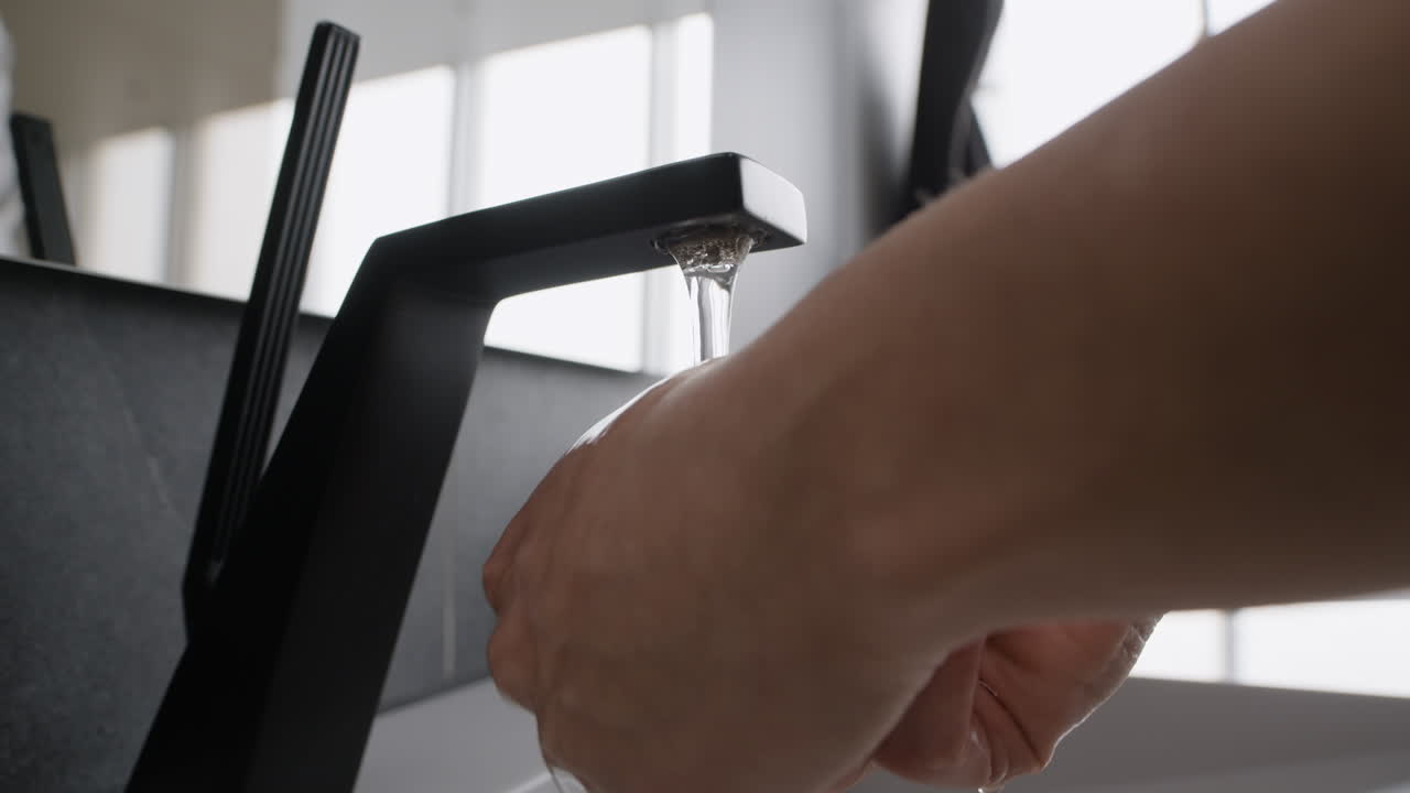 Washing Hands at Modern Bathroom Sink
