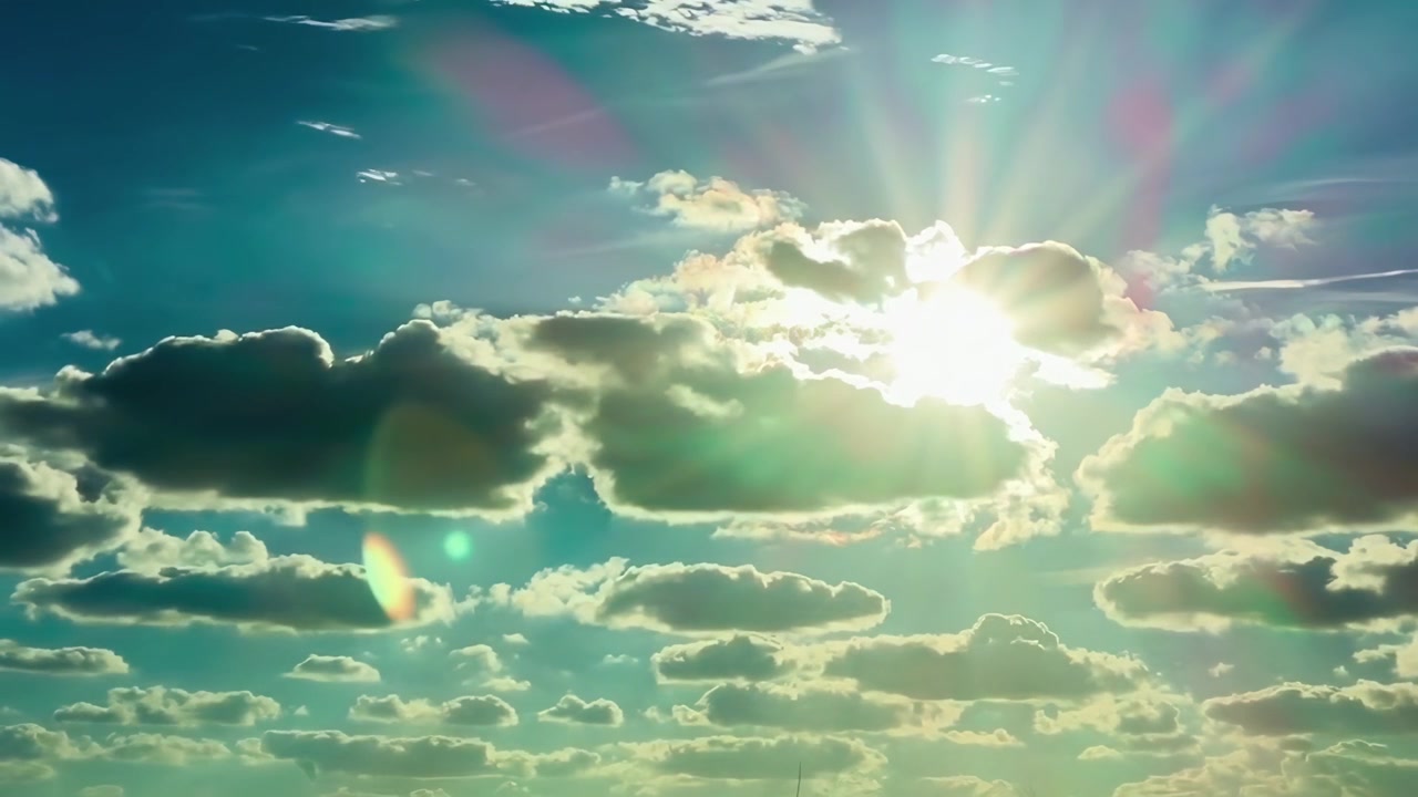 Raggi di sole che filtrano tra le nuvole in un cielo azzurro