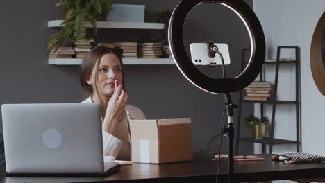 satisfied cute vlogger girl taking out of a box the cosmetic products that she has received and showing them to the camera