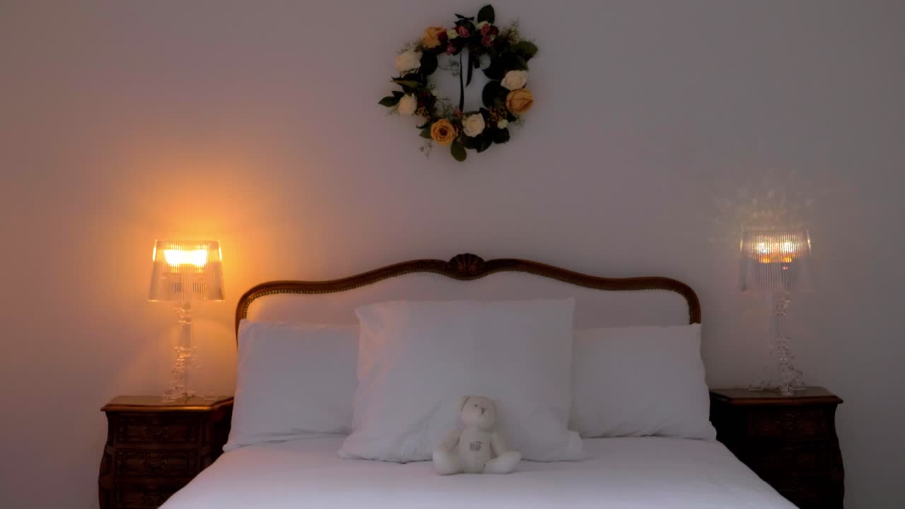 Indoor setting of a bedroom with lights on and flower decorations on the wall at Maison Vias, France. The space exudes warmth and elegance, a blend of soft lighting and charming floral accents.