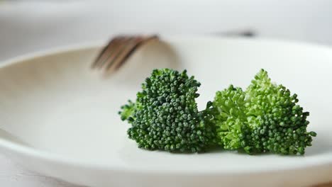 Picking raw broccoli with fork ,