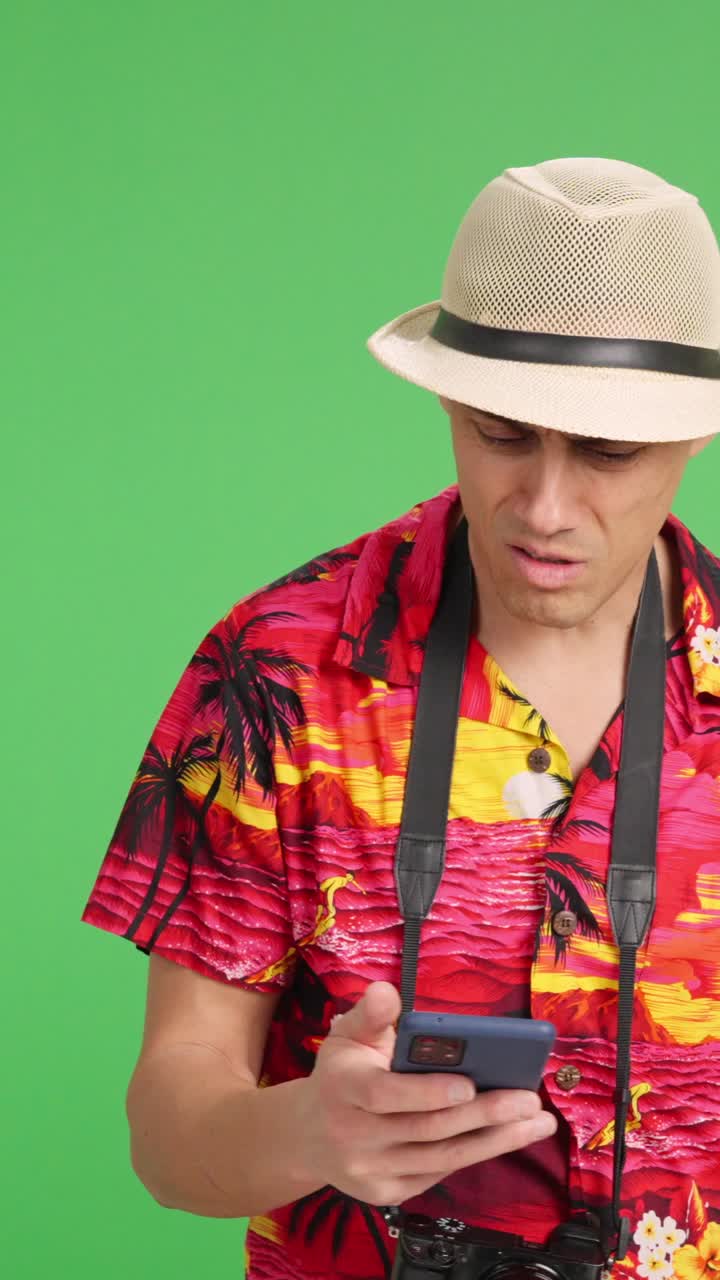 Confused tourist using smartphone and asking for directions on green screen