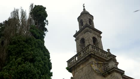 close up of church bell tower on santo eusebio da peroxa in coles, galicia, spain, with cloudy background