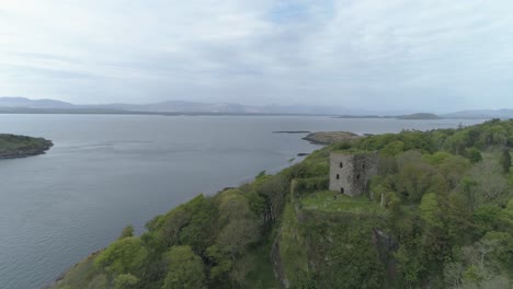 Luftaufnahme-über-Dunollie-Castle,-Oban,-Richtung-Nordwesten-über-Die-Bäume-Hinaus-Zum-Meer