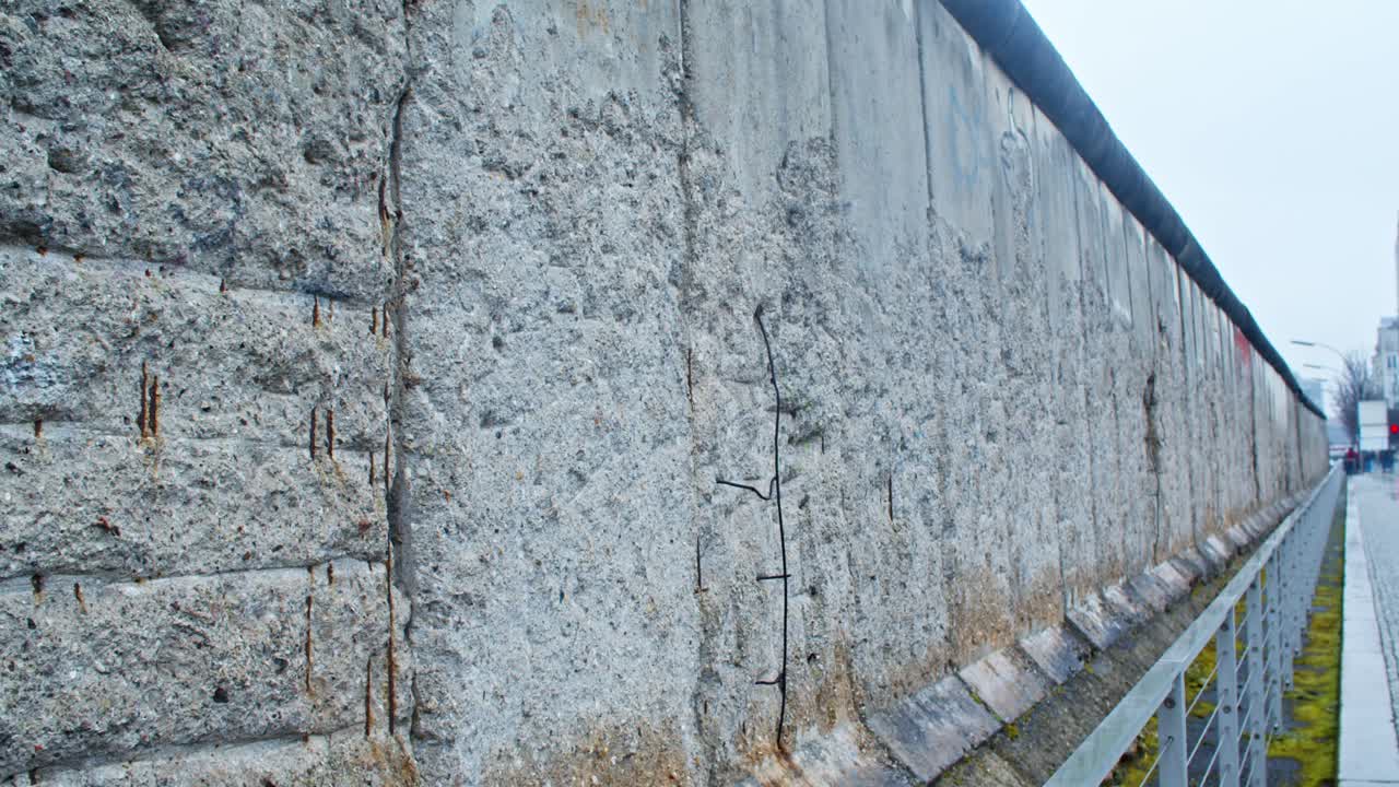 Closeup of parts of the Berlin Wall deteriorating on a cloudy day, handheld