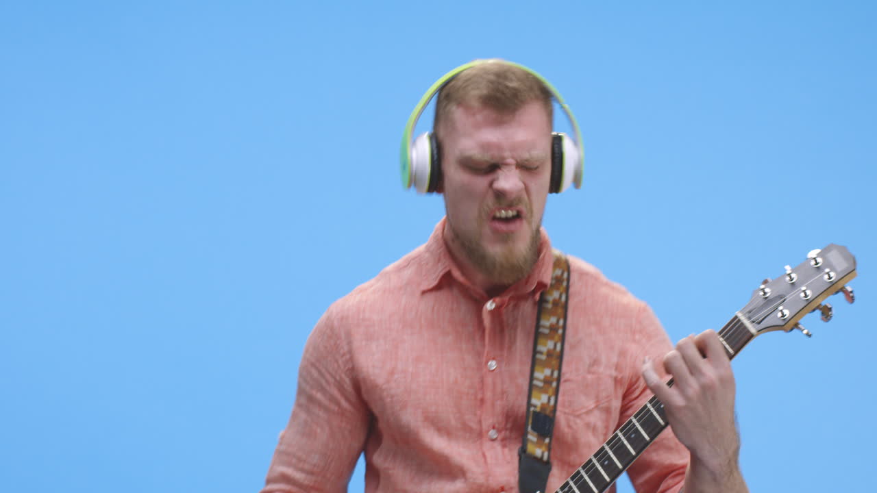 Man Playing Acoustic Guitar with Headphones