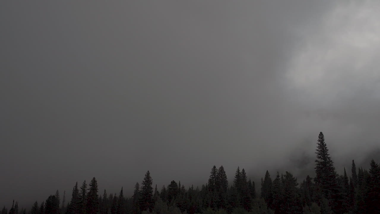 lapso de tiempo de oscuras nubes de tormenta rodando a través de las montañas