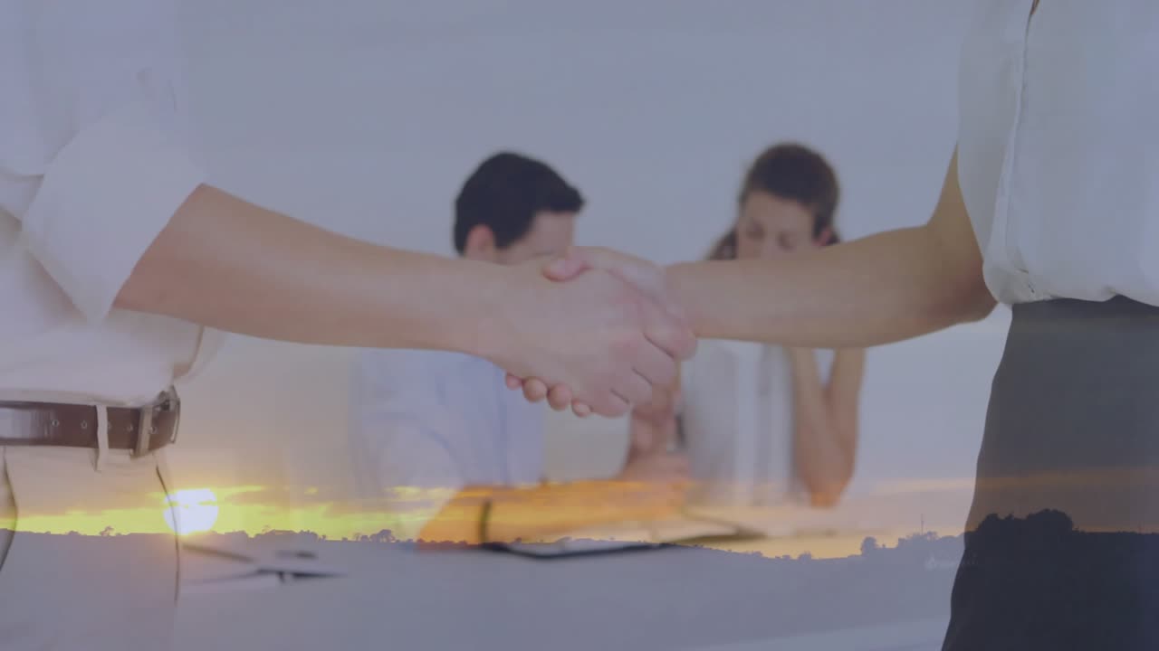 Colleghi che si stringono la mano, invitando i clienti a una riunione d'affari con un tablet, con un tramonto in sovrapposizione