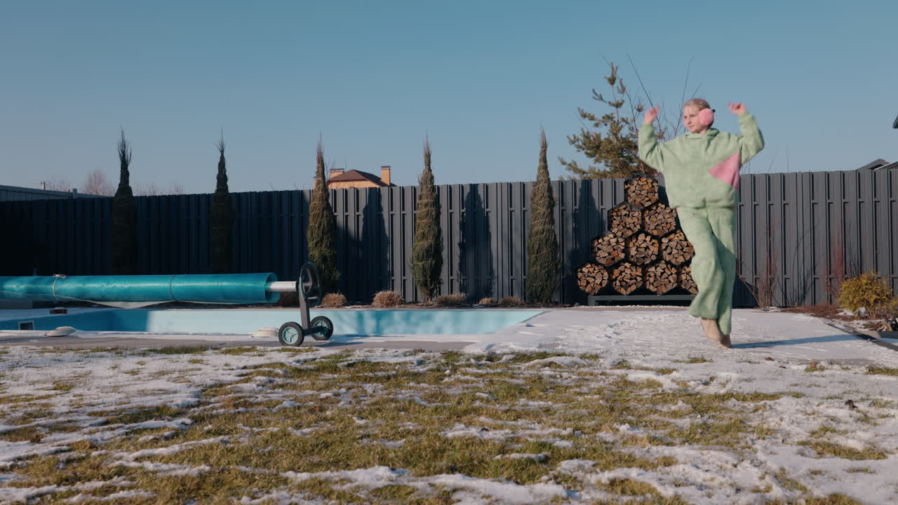 수영장 근처의 겨울 정원에서 춤을 추는 여자