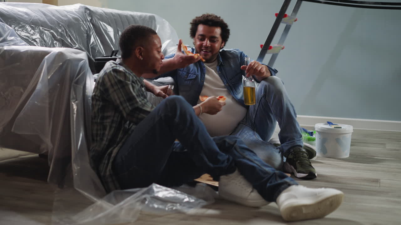los trabajadores afroamericanos cenan con pizza y cerveza