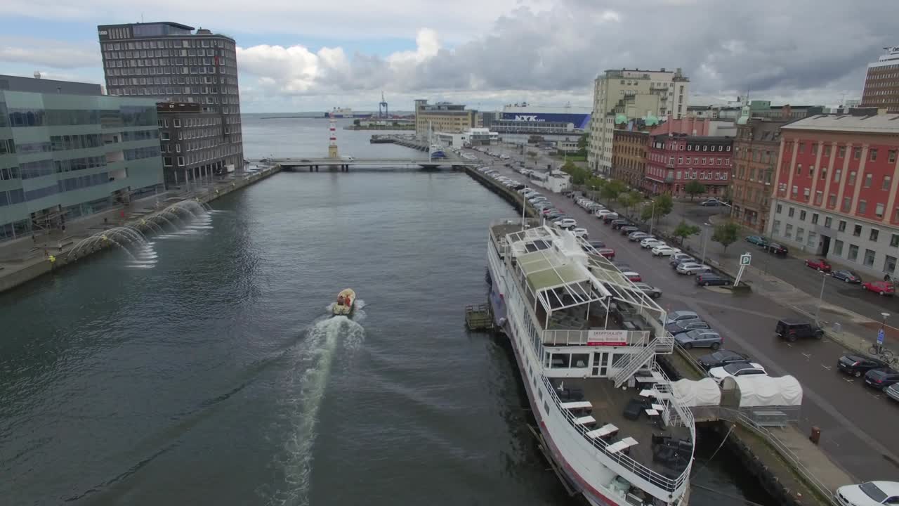 스웨덴 말모 시의 운하에서 볼 수 있는 공중 사진. 배경에는 배, 항구, 큰 배가 있는 운하 위를 날아다니는 드론 촬영.