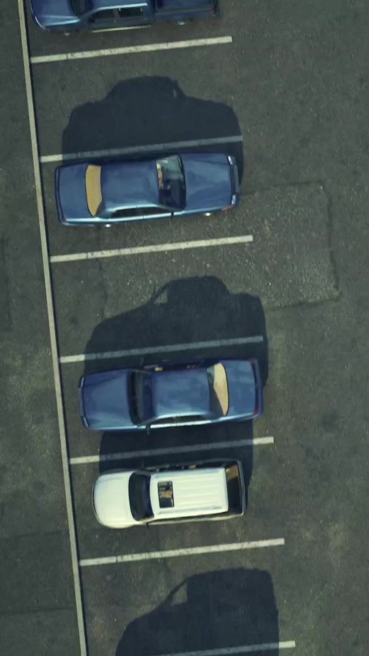 Parking lot view with multiple cars arranged in different directions