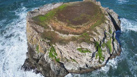 Beautiful-4K-aerial-drone-shot-with-blue-skies-looking-over-giant-rock-with-flying-Seagulls-at-Bandon-beach-in-Oregon