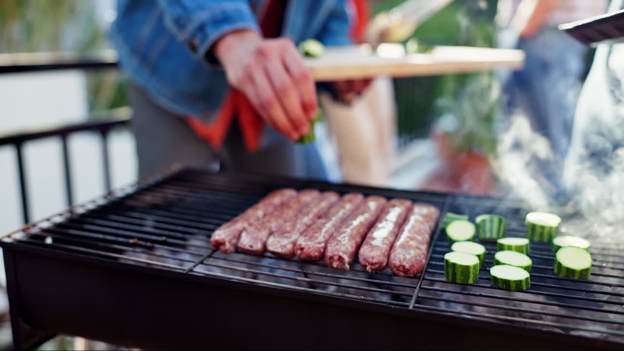 Grilling sausages and zucchini on a barbecue