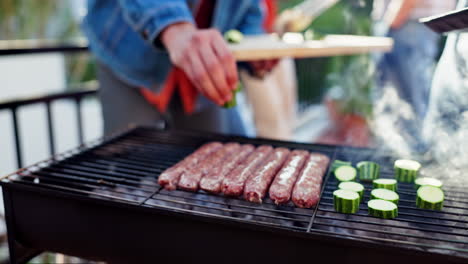grilling sausages and zucchini on a barbecue