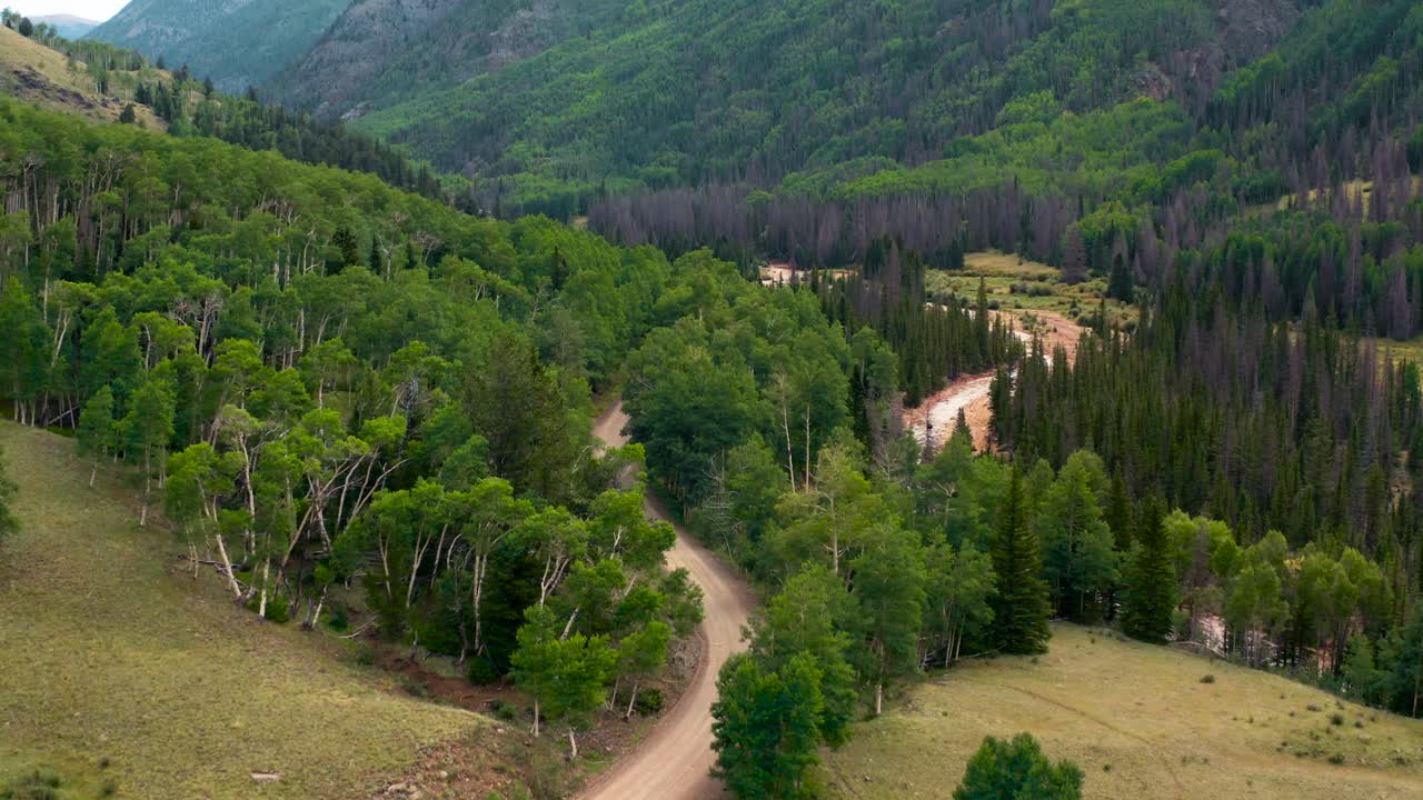 un sendero de campamento en el interior rodeado de montañas verdes y exuberantes.