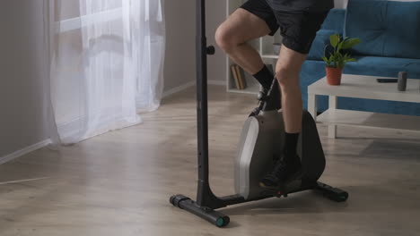 training with exercycle for wellness and health closeup of legs of middle aged man doing sport at home physical activity