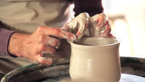 mid section of potter making pot