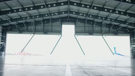 empty airplane hangar with open doors