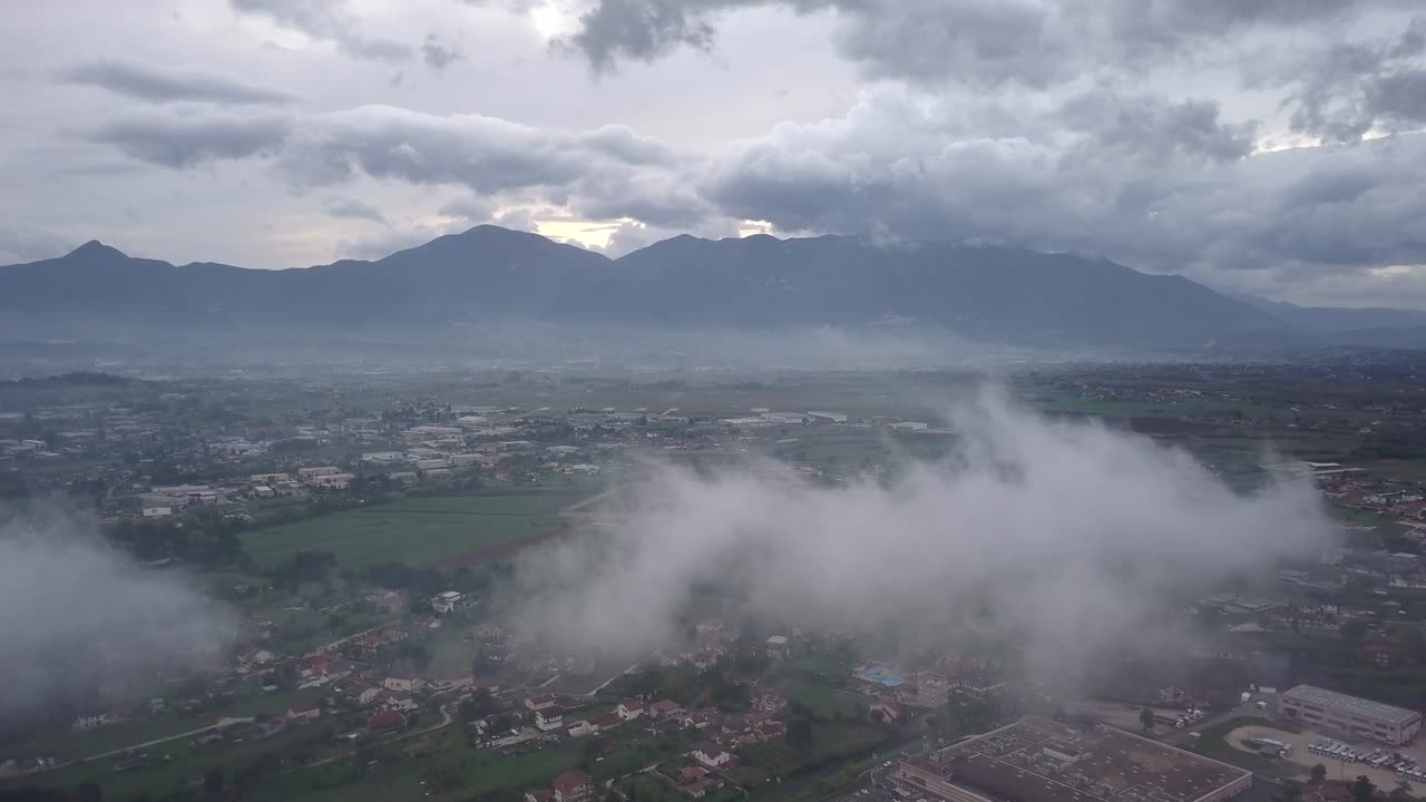 Video dari atas. Pemandangan udara dari drone yang terbang menembus awan. Pedesaan Italia sebagai latar belakang