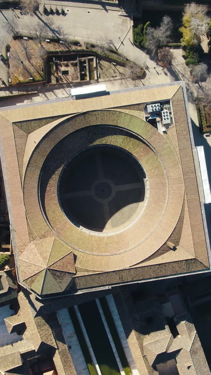 Ripresa aerea verticale dall'alto che rivela il cortile circolare e il design rinascimentale del Palazzo di Carlo V all'interno del complesso dell'Alhambra a Granada, Spagna.