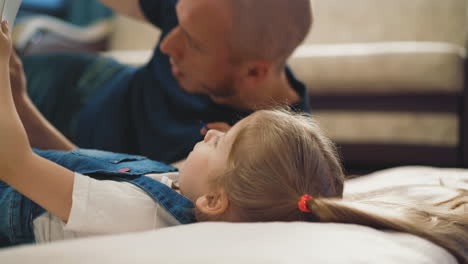 closeup little girl lies on floor and draws numbers