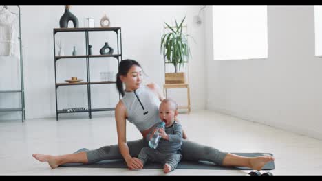 mother and baby doing yoga at home