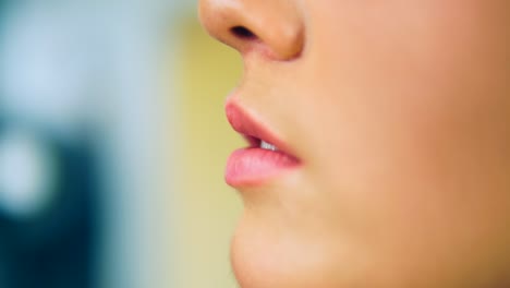 Close-Up-view-of-a-professional-makeup-artist's-hand-finishing-lips-makeup-working-in-beauty-fashion-industry.-Close-Up-view-of-and