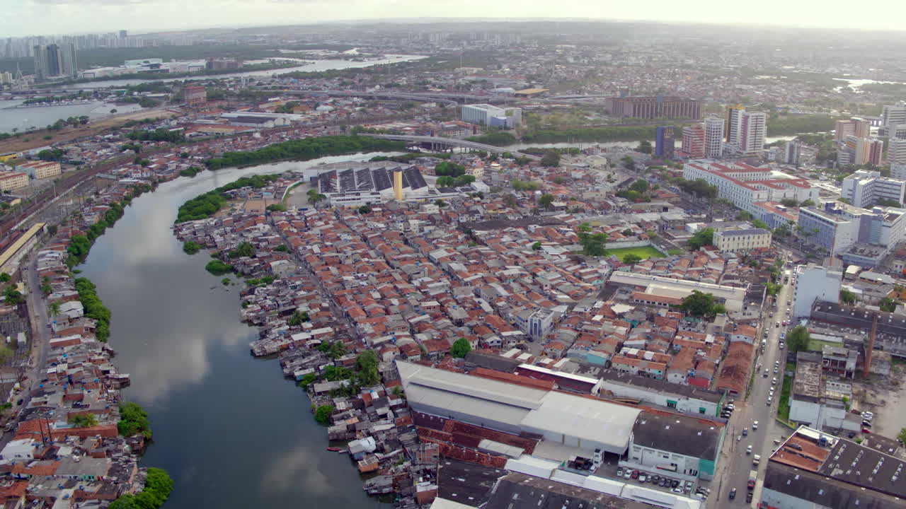 Recife's urban landscape from above, revealing judicial buildings standing near informal settlements on the river.