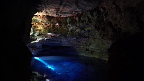 the stunning natural cave pool the enchanted well or poço encantado in the chapada diamantina national park in northeastern brazil with beautiful clear blue water and a sun ray shining into the cave