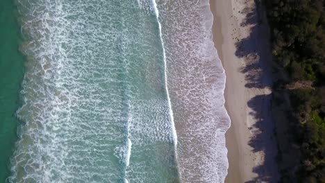 Drone-view-looking-down-at-ocean-waves-and-beach-at-Inverloch,-Victoria,-Australia