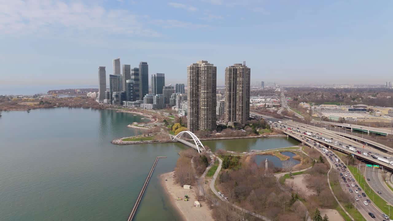Palace Place Condo Buildings in Canadian neighborhood of Etobicoke, Toronto. Lake Ontario and humber bay arch bridge at busy Gardner Expressway. Skyline skyscraper in background. Aerial wide shot.