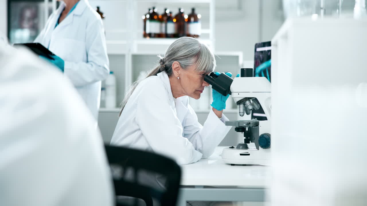 Scientist working in a laboratory with a microscope