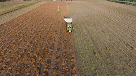 Luftaufnahme:-Rückwärtsfliegen-Vor-Einem-Traktor,-Der-Den-Boden-Pflügt