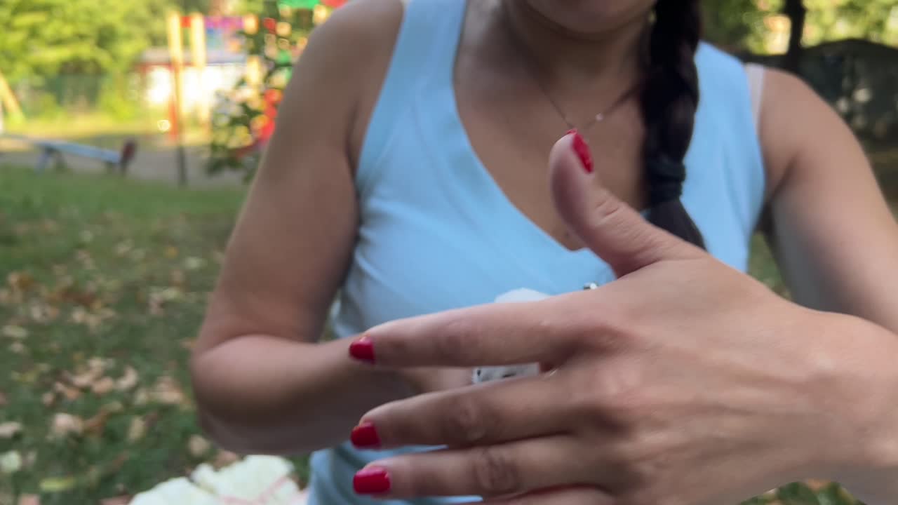mujer sosteniendo un hámster blanco en un parque