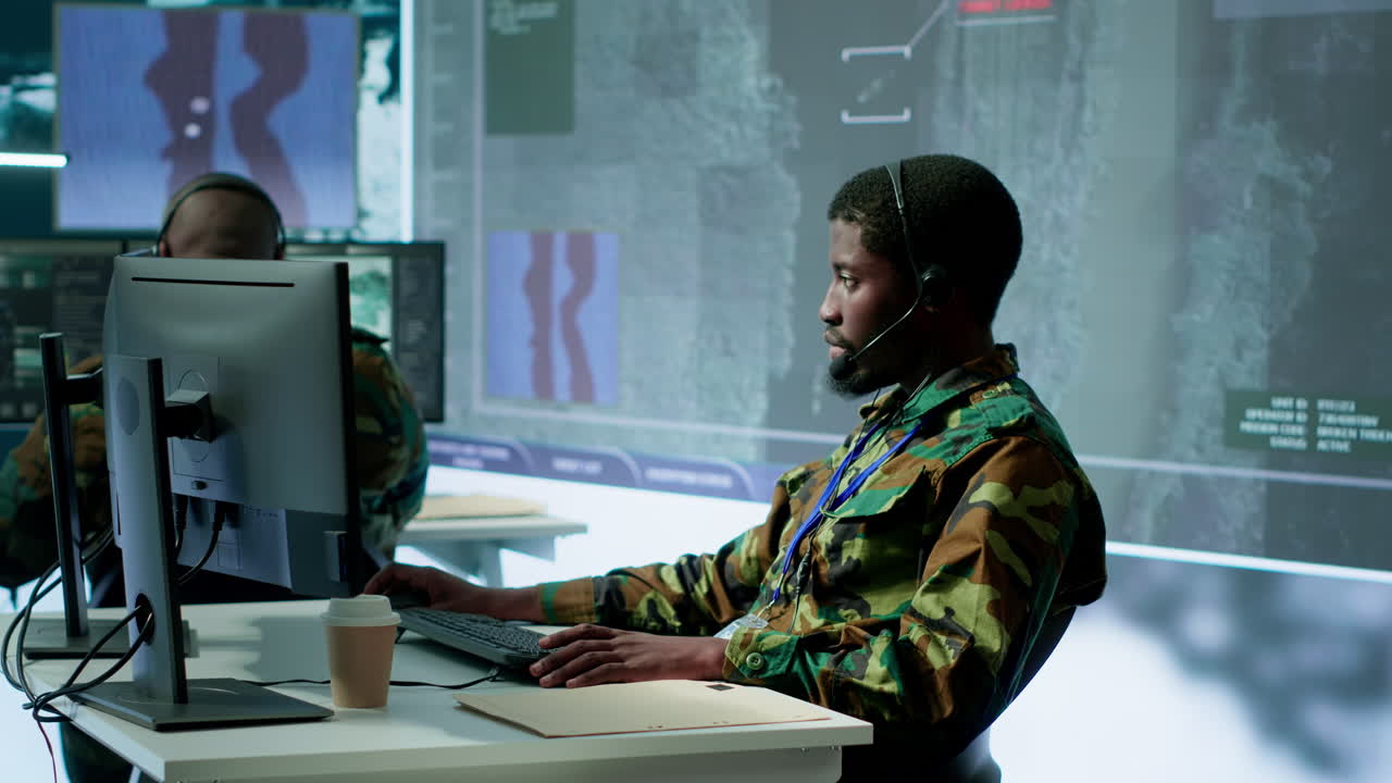 Team of military specialists in command post monitoring satellite data