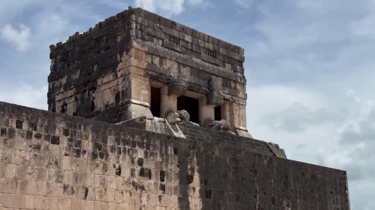 Handheld close-up panning shot of the Temple of the Jaguars atop the Great Ball Court at Chichen Itza in Yucatan, Mexico. 4K